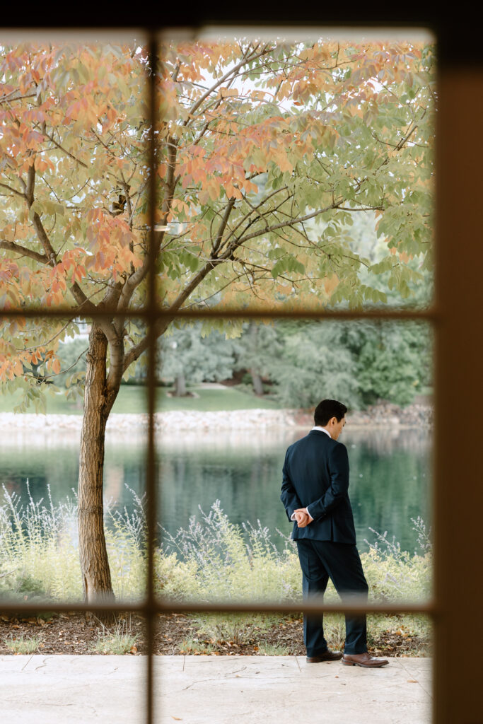 A groom waiting in front of the lake at the Broadmoor