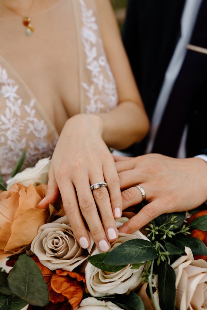 Wedding details showing a couple's rings with a Flintwood Floral bouquet