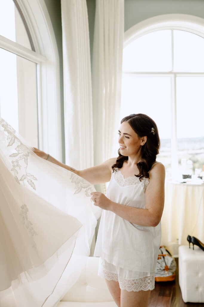 bride looking at her dress in getting ready room
