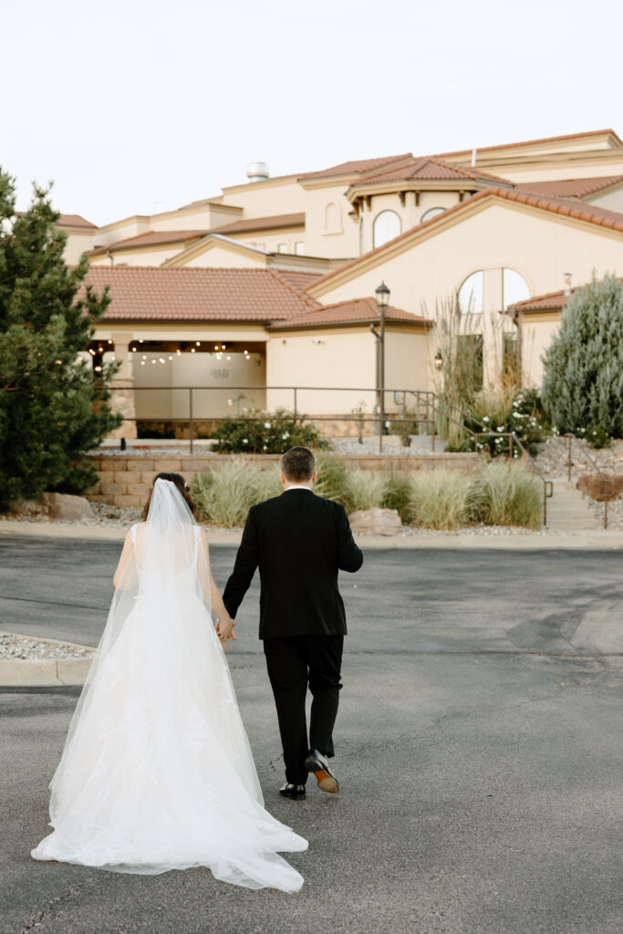 bride and groom walking towards Colorado Springs wedding venue