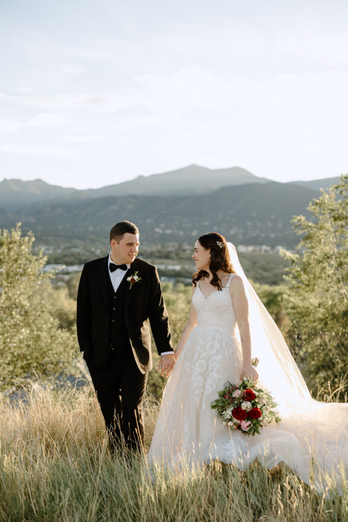 sunset photo of bride and groom walking in front of colorado springs mountains