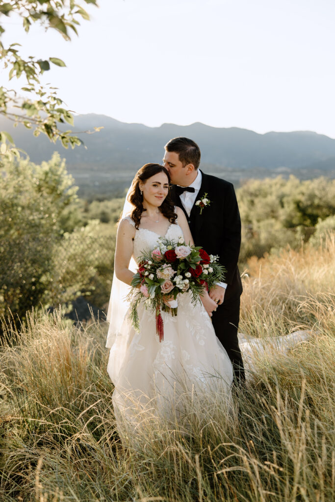 sunset photos of groom kissing bride in the mountains of Colorado Springs
