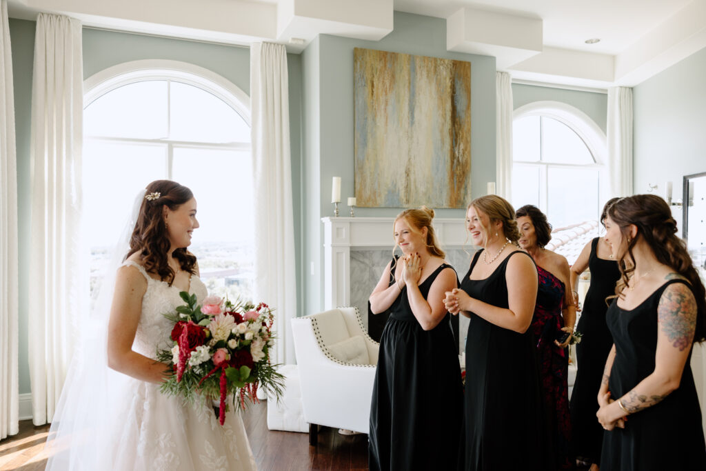 bridesmaids reacting to bride in getting ready room